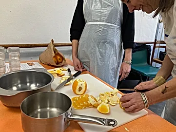 Personne découpant une orange lors de l'aletier cuisine